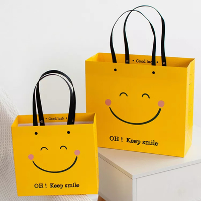 ISO Shock Resistant Smile Face Kraft Paper Bags Yellow Square Bottom Paper Bag